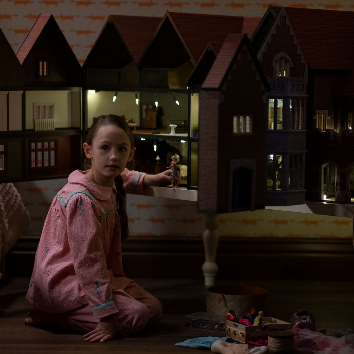 A pequena Flora ao lado da sua misteriosa casa de boneca